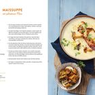 ***MAISSUPPE mit gebratenen Pilzen***

Eine cremige Suppe mit braunen Pilzen, Kräutern, Speck und Croutons in einem tiefen Teller. Rechts kleines Schälchen.
