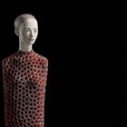 "Museum". Skulptur eines Menschen mit runder Musterstruktur auf schwarzem Hintergrund.