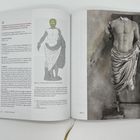 Seite mit Text über römische Statuen, links eine Farbzeichnung, rechts eine Fotografie eines kopflosen Torso mit Umhang.