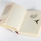 Ein Buch liegt geöffnet da, der Text „WAS AM MEISTEN ZÄHLT“ ist zu sehen, daneben die Illustration eines Kolibris.