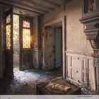 6, 2017. Ein altes, verlassenes Zimmer mit hölzernen Doppeltüren. Sonnenschein fällt durch Glasfenster und beleuchtet den Raum.