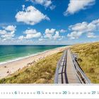 Es ist Juni 2021. Ein Strandweg führt entlang eines grünen Hügels zum Strand mit blauem Meer und einigen Wolken am Himmel.