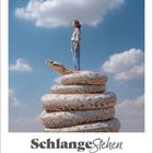 "Schlange Stehen" steht unter einem Kalender für Mai 2027. Eine Person steht auf einer aufgerollten Riesenschlange in der Luft.