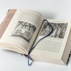 Doppelseite eines Buches mit Fotos und einem blauen Leseband. Texte auf den Seiten beinhalten Informationen zu Fresken.
