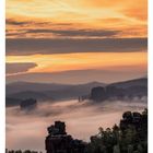 05 FEBRUAR, Kalender zeigt 01 bis 07. Berglandschaft mit Nebel, orangefarbenem Himmel bei Sonnenuntergang.