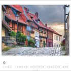 Quedlinburg, Harz, Sachsen-Anhalt. Kopfsteinpflasterstraße mit bunten Fachwerkhäusern und blühenden Pflanzen.