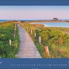 Der Text lautet "Juni 2027." Ein Holzsteg führt durch grüne Wiesen, im Hintergrund ein stiller See unter einem klaren Himmel.