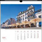 Kalenderbild für Juni, englisch und französisch, zeigt eine belebte Straßencafé-Szene mit Sonnenschirmen und alten Gebäuden.