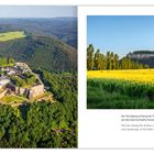 Der Rundgang entlang der Ringmauer bietet einen faszinierenden Ausblick auf die märchenhafte Felslandschaft. Links: Burg auf bewaldetem Hügel; rechts: gelbes Feld und Bäume.