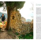 Texte: "Einleitung" und "Altes Land der Adler". Ein Wanderer mit Rucksack geht durch ein steinernes Tor in einer ländlichen Umgebung.