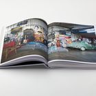 Ein aufgeschlagenes Buch zeigt eine Garage mit einem grünen Auto, Gitarren und Plakaten an den Wänden.