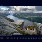 03. März. Wie ein natürlicher Aussichtspunkt ragt der Felsen über einen norwegischen Fjord. Wolken am Himmel, dramatische Szenerie.