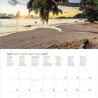 April-Kalender mit Wochentagen in mehreren Sprachen. Oben: Strand mit Palme bei Sonnenuntergang.