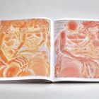 Zwei farbenfrohe Illustrationen in einem Buch. Links Menschen engumschlungen in sanften Orangetönen, rechts ähnlich gestaltet.