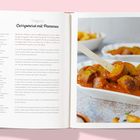 Rezept für vegane Currywurst mit Pommes. Foto: Currywurst in Soße mit gelbem Gewürz in einer Schale, Pommes im Hintergrund.