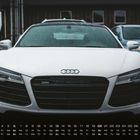 "Audi R8, 6. Kalender am unteren Rand. Im Vordergrund steht ein weißer Sportwagen mit dem Audi-Logo auf dem Kühlergrill."