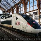 Kalender mit Zugmotiv: "TGV inOui" steht auf dem weißen Hochgeschwindigkeitszug im Bahnhof. Unten Monatsübersicht.