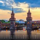 „Oberbaum Brücke“ und ein Kalender. Zwei Türme der Brücke, Abendhimmel, Wasser, Spiegelung, beleuchtet, Architektur.