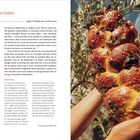 "Kräuter-Olivenöl-Challah" und "Ergibt 2 Challahs (für 4–6 Personen)". Hände halten geflochtenes Brot mit Kräutern vor Zweigen.