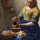 Gemälde einer Frau, die Milch aus einem Krug in eine Schüssel gießt. Auf dem Tisch liegen Brot und ein blauer Stoff.