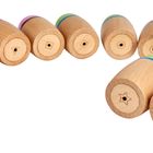 Holzzylinder mit eingravierten Formen (Star, Dreieck). Bunte Ringe in Grün, Blau, Rot und Pink.