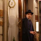 "Sardi's Restaurant and Grill," "The Little Bar". Ein Mann in Anzug und Hut tritt aus einer Tür, Neonlicht schimmert.