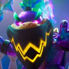 Ein buntes Wesen mit einem leuchtenden Zickzack-Muster auf einem schwarzen Halstuch, hält einen Stab. Fantasievolle Szene.