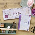 Wochenplaner mit "Believe in Book Love", daneben ein Notizbuch "2027 In my Romance Era". Schreibwaren umgeben sie.
