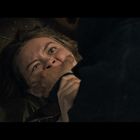 Keine Texte vorhanden. Eine Frau liegt auf dem Boden, ihr Gesicht ist angstvoll, während jemand ihre Mündung hält.
