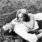 Text im Bild: "2" unten rechts. Ein Mann liegt auf einer Wiese, eine Frau lehnt sich liebevoll auf ihn.