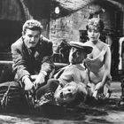 Keine lesbaren Texte. Ein dramatisches Schwarz-Weiß-Szenario mit vier Personen in einem Keller. Eine liegt gefesselt.