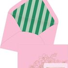Ein pinker Umschlag mit grün gestreiftem Innenfutter. Darauf eine Karte mit Blumenzeichnung und Platz für Text.