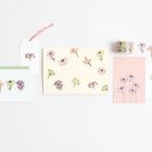 Eine Sammlung von Karten und Notizen mit Blumenmotiven auf hellem Hintergrund.