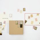 Auf Karten steht "SENDING YOU A HUG" und "SENDING LOVE". Daneben sind Briefmarken mit Pflanzenmotiven auf hellem Hintergrund.