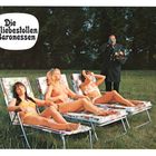 Text: "Die liebestollen Baronessen". Drei Frauen sonnen sich auf Liegestühlen, ein Butler mit Tablett steht daneben.