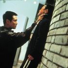 Zwei Männer in intensiver Auseinandersetzung, einer hält den anderen an einer Backsteinwand fest.