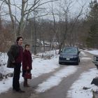 Ein Mann und eine Frau stehen auf einem schneebedeckten Weg. Im Hintergrund ein SUV mit der Aufschrift "Range Rover".