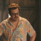 Ein Mann steht in einem Holzraum. Er trägt ein bunt gemustertes Hemd und eine Brille. Es sind Regale im Hintergrund.