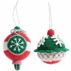 Zwei gehäkelte Weihnachtskugeln mit Schnee- und Sternmustern, in Rot und Grün, an silbernen Fäden hängend.