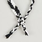 Schwarz-weiß geflochtene Schnüre in einem dekorativen Muster verknotet.