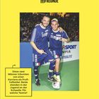 „Montag, 22.02.“ steht in großen Buchstaben. Zwei Männer in blauen Trikots halten sich umarmt, lächelnd mit einem Fußball.