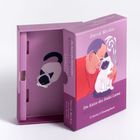„Die Katze des Dalai Lama WEISHEITSORAKEL“ auf einer lila Box. Illustration: Mann mit Brille hält Katze.