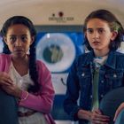 Vier Kinder sitzen in einem Bus, sie wirken nachdenklich und neugierig.