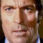 Keine erkennbaren Texte im Bild. Ein Mann schaut ernst mit zusammengezogenen Augenbrauen und leicht geöffnetem Mund.