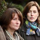 Zwei Frauen mit ernstem Gesichtsausdruck, eine trägt einen bunten Schal. Die Frau im Vordergrund ist unscharf.