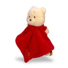 Ein Plüschbär mit rotem Umhang, der bekanntermaßen freundlich aussieht. Der Bär hat ein goldfarbenes Emblem.