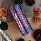 "Buchrücken mit Text: 'CURSEBREAKER', 'I WILL NEVER SURRENDER'. Dekoriert mit blauen Blumen, umgeben von Rosen.