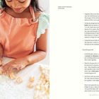 "SWEET POTATO GNOCCHI, CONTINUED"  
Ein Kind in einer orangefarbenen Schürze formt Teig auf einer bemehlten Oberfläche.