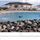 Los Cristianos. Steiniger Vordergrund, dahinter Strand mit Menschen, blaues Meer und Boote. Im Hintergrund Stadt und Hügel.
