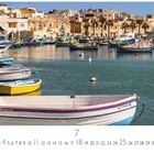 Boote im Hafen von Marsaxlokk, Malta, umgeben von Gebäuden und Palmen. Kalender unten mit Zahlen und Monat Juli.